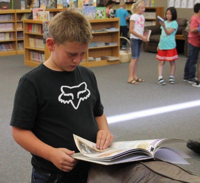 A-student-looks-through-a-book-that-he-might-want-from-the-Reading-Leveling-program-at-Castle-Heights-Elementary..jpg